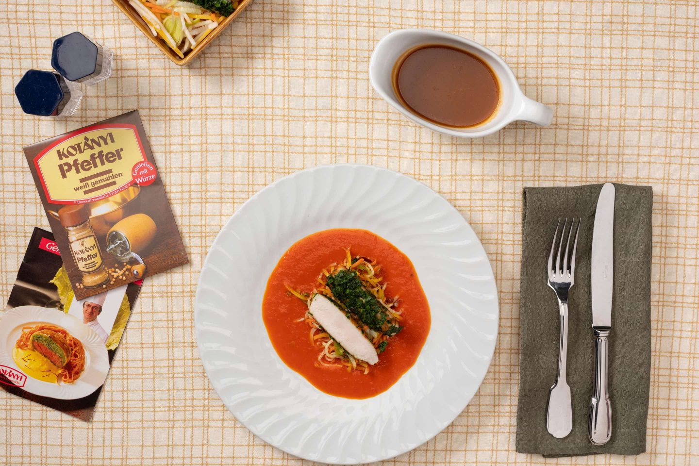 Корейка кролика со сливочным соусом с паприкой и овощами, рядом лежит упаковка белого перца.